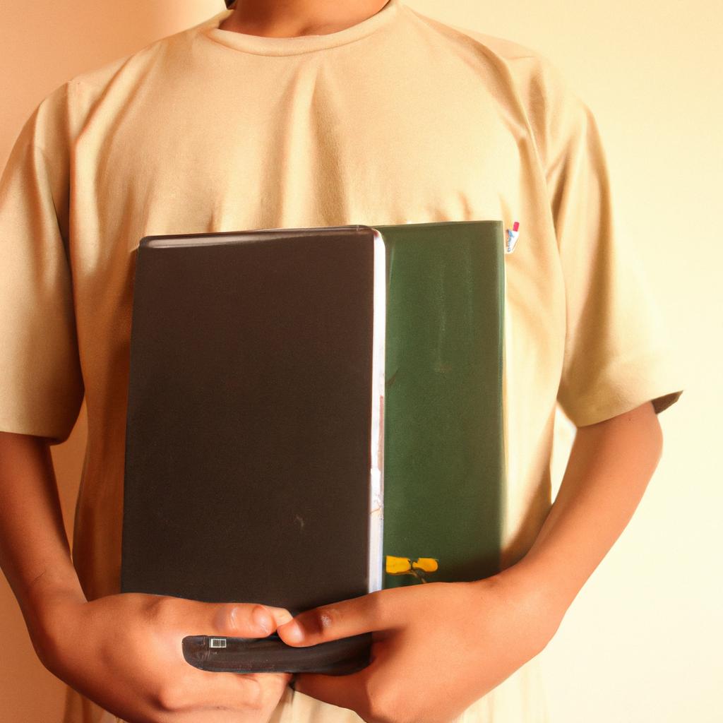 Person holding textbooks and laptop